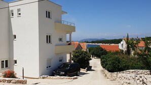 A modern two-story building with a car parked in front. - Apartments MIA Bilo 887 (Primosten)