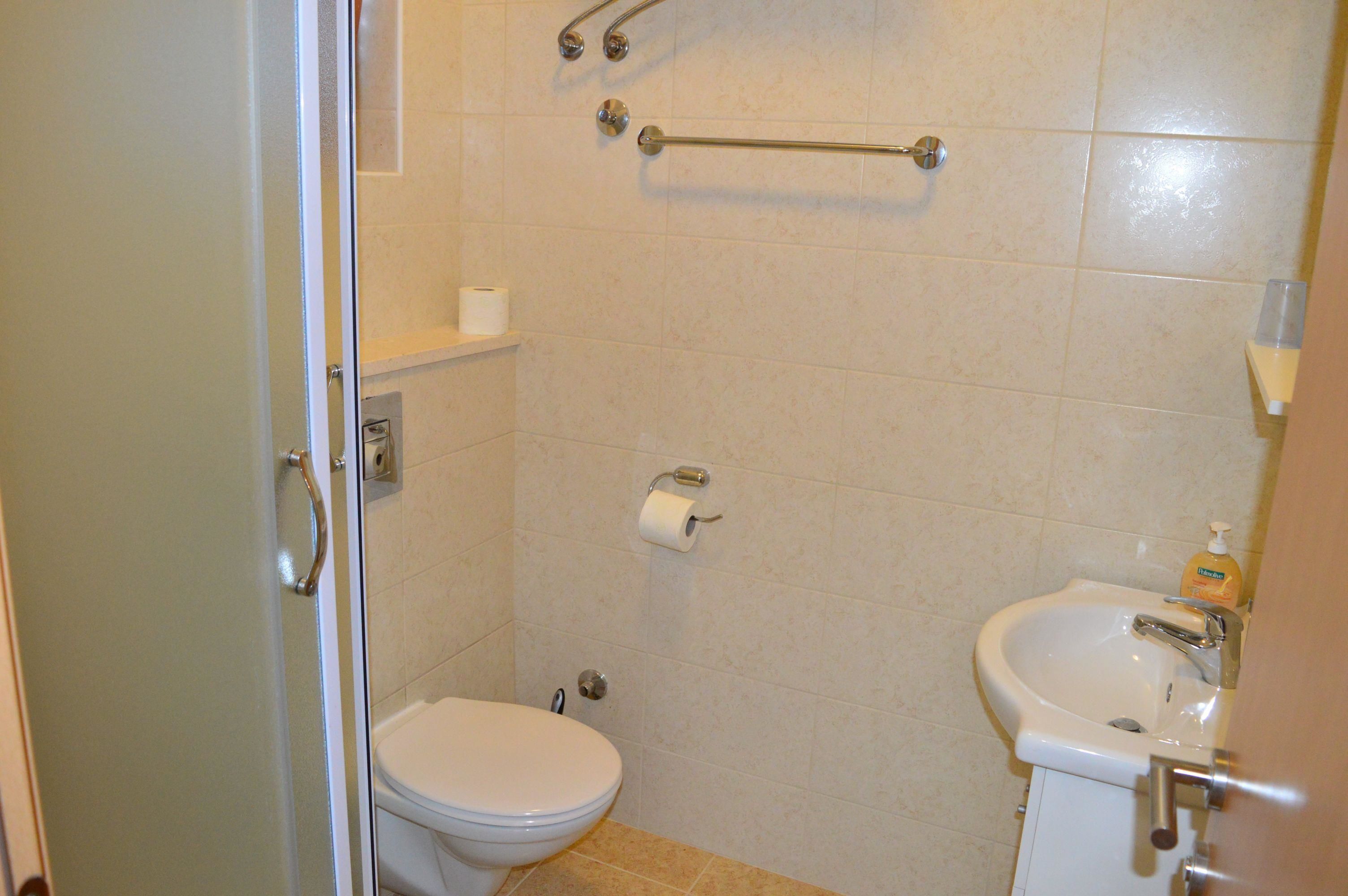 A bathroom with a toilet, a sink, and a shower.