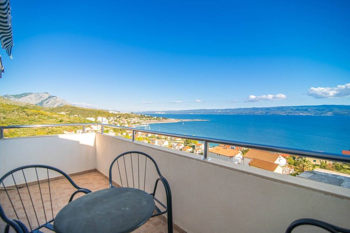 A balcony with a view of the sea and mountains.