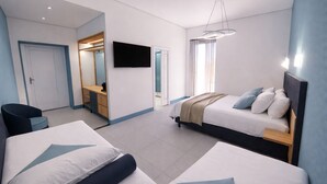 Una camera d'albergo moderna con due letti, una TV, una scrivania e un armadio a muro.