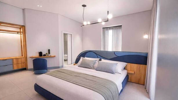 Una camera da letto moderna con un letto grande, comodini, una scrivania e un armadio.