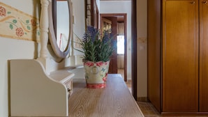 A wooden cabinet, a white dresser, and a mirror on a wooden floor. - Maria's Countryside House (Corfu)