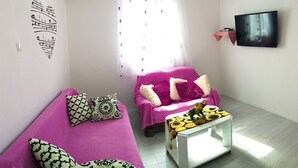 A room with two beds, a TV, and a window with curtains. - Apartments Cagalj (Trogir)