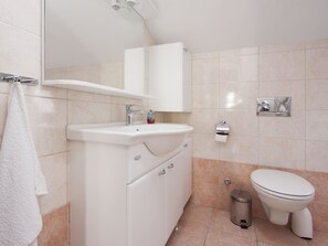 A modern bathroom with a white sink, mirror, and toilet. - Apartment Dragica / Two Bedroom A1 (Sibenik)