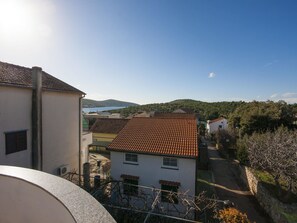 A residential area with houses, a clear sky, and a distant view of hills and water. - Apartment Dragica / Two Bedroom A1 (Sibenik)
