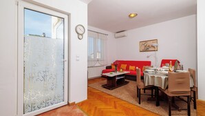 Un coin repas avec une table dressée pour quatre personnes, un canapé et une table basse.