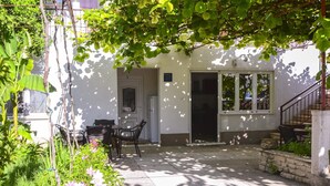 A courtyard with a white building, a door, and a staircase. - Apartments Konta (Kastela)