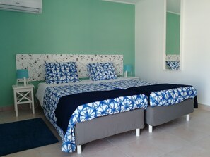 A bedroom with a bed, nightstands, a mirror, and a wall-mounted air conditioner. - Ocean's 7 - Lagos Guest House (Lagos)