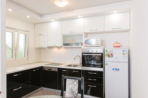 Appartement, plusieurs lits | Cuisine privée | Plaque de cuisson, batterie de cuisine, vaisselle et ustensiles