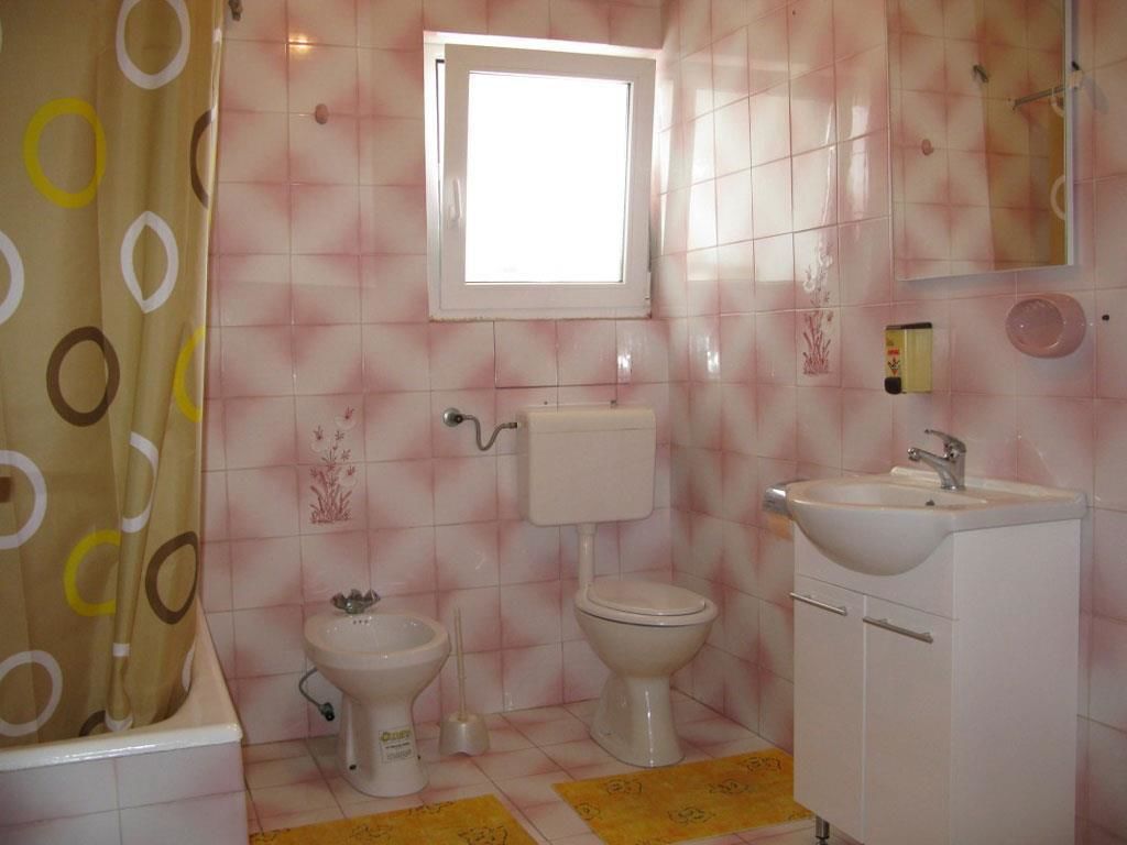 A bathroom with a toilet, bidet, and sink.