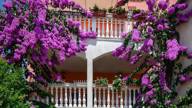 A two-story building with a balcony, a swimming pool, and outdoor seating. - Apartments Salčinović (Medulin)