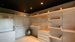 Un armario moderno y bien iluminado, con muebles de madera y múltiples opciones de almacenaje, incluyendo estantes y cajones.
