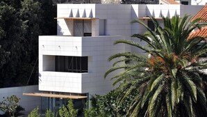 Un edificio moderno con techo plano, ventanas amplias y un balcón.