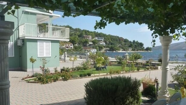 A paved walkway with a view of a body of water and buildings in the background.