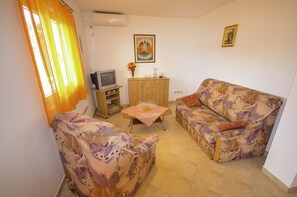 Apartment, Mehrere Betten | Wohnzimmer | Fernseher