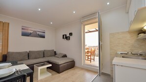 Apartamento, varias camas | Sala de estar | Una televisión