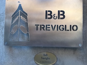 A metal plaque with the text "B&B Treviglio" and a phone number.