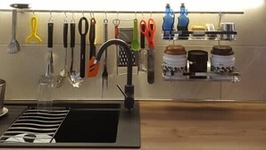 Een moderne keuken met een RVS spoelbak, een magnetron en een afzuigkap.