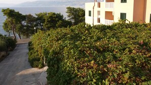 Un edificio con balcón que da a un cuerpo de agua y montañas.