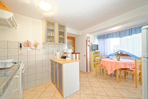Appartement, plusieurs lits | Cuisine privée | Plaque de cuisson, batterie de cuisine, vaisselle et ustensiles