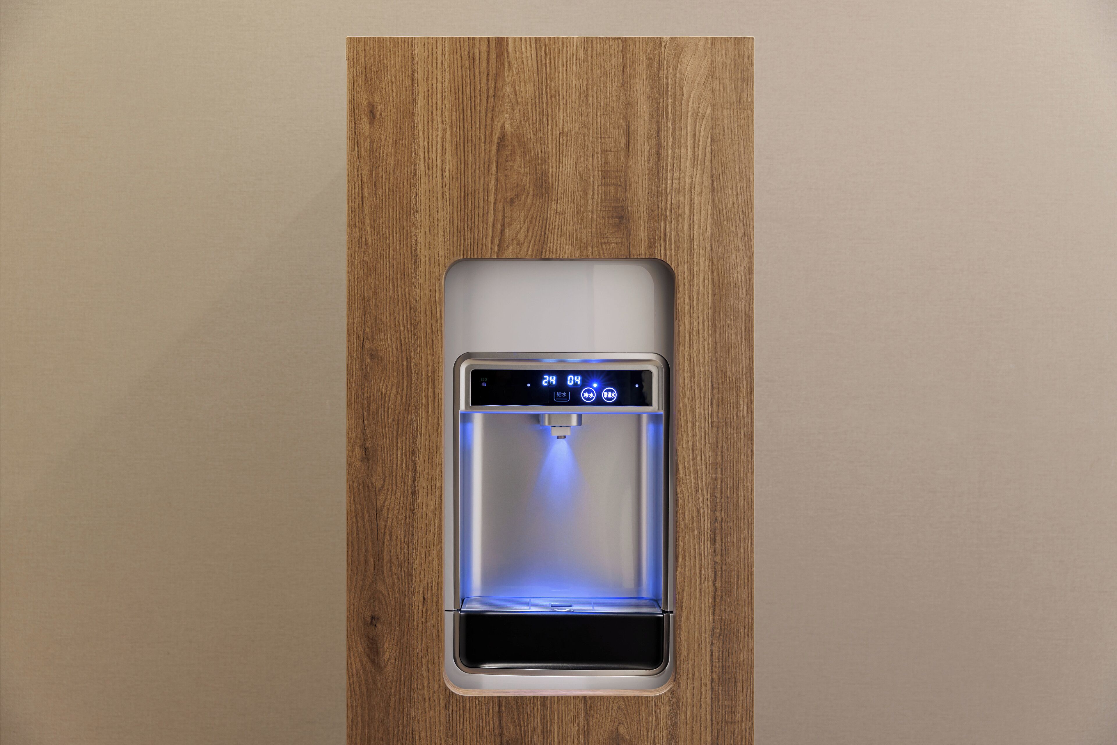 Un dispenser di acqua con display digitale, integrato in un pannello di legno.
