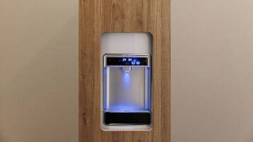 Un dispenser di acqua con display digitale, integrato in un pannello di legno.