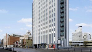 A tall, modern hotel with a grid of windows and balconies.