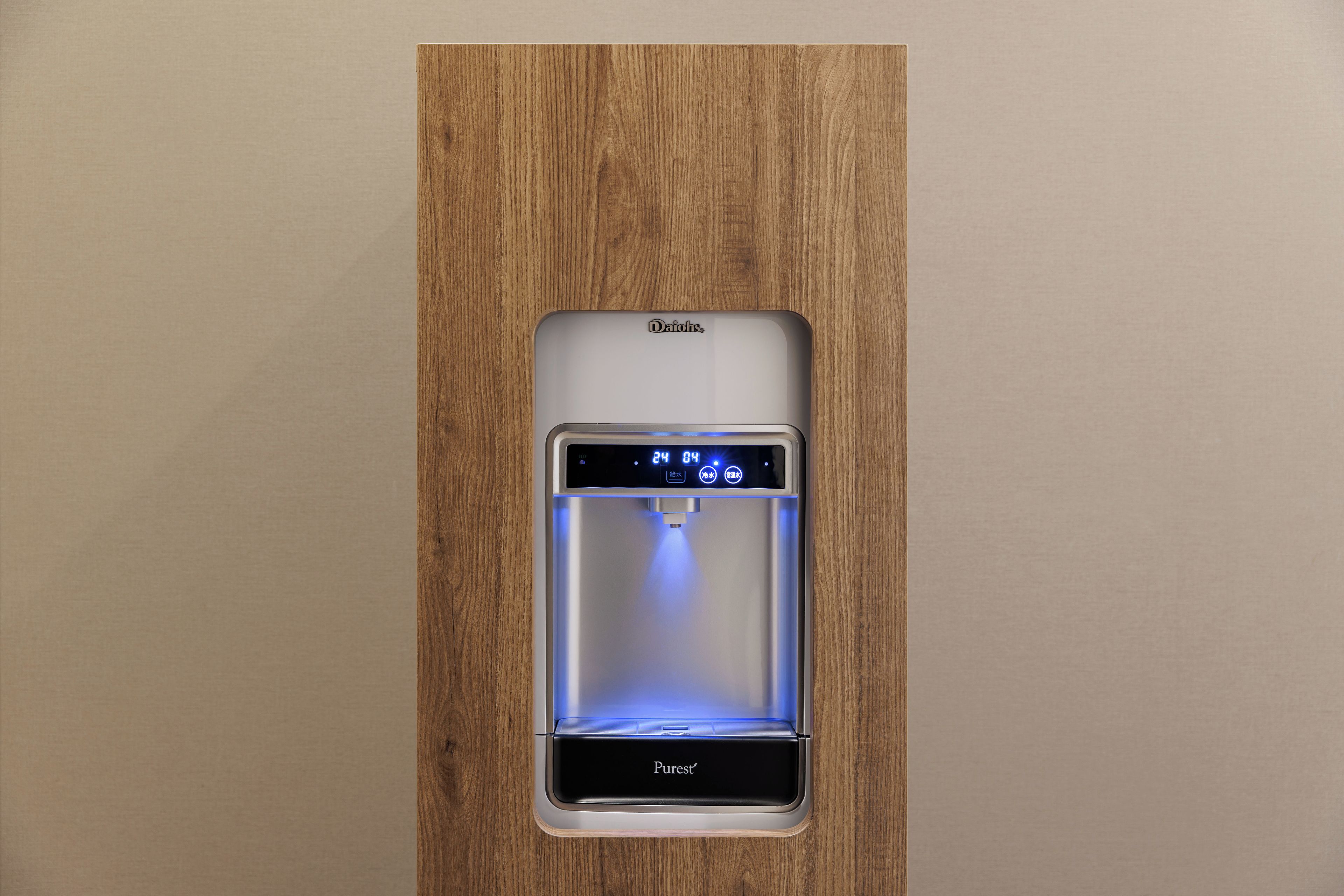 A water dispenser with a digital display, branded by Daikin, installed in a wooden panel.