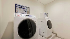 Two front-loading washing machines in a laundry room with control panels and instructions.