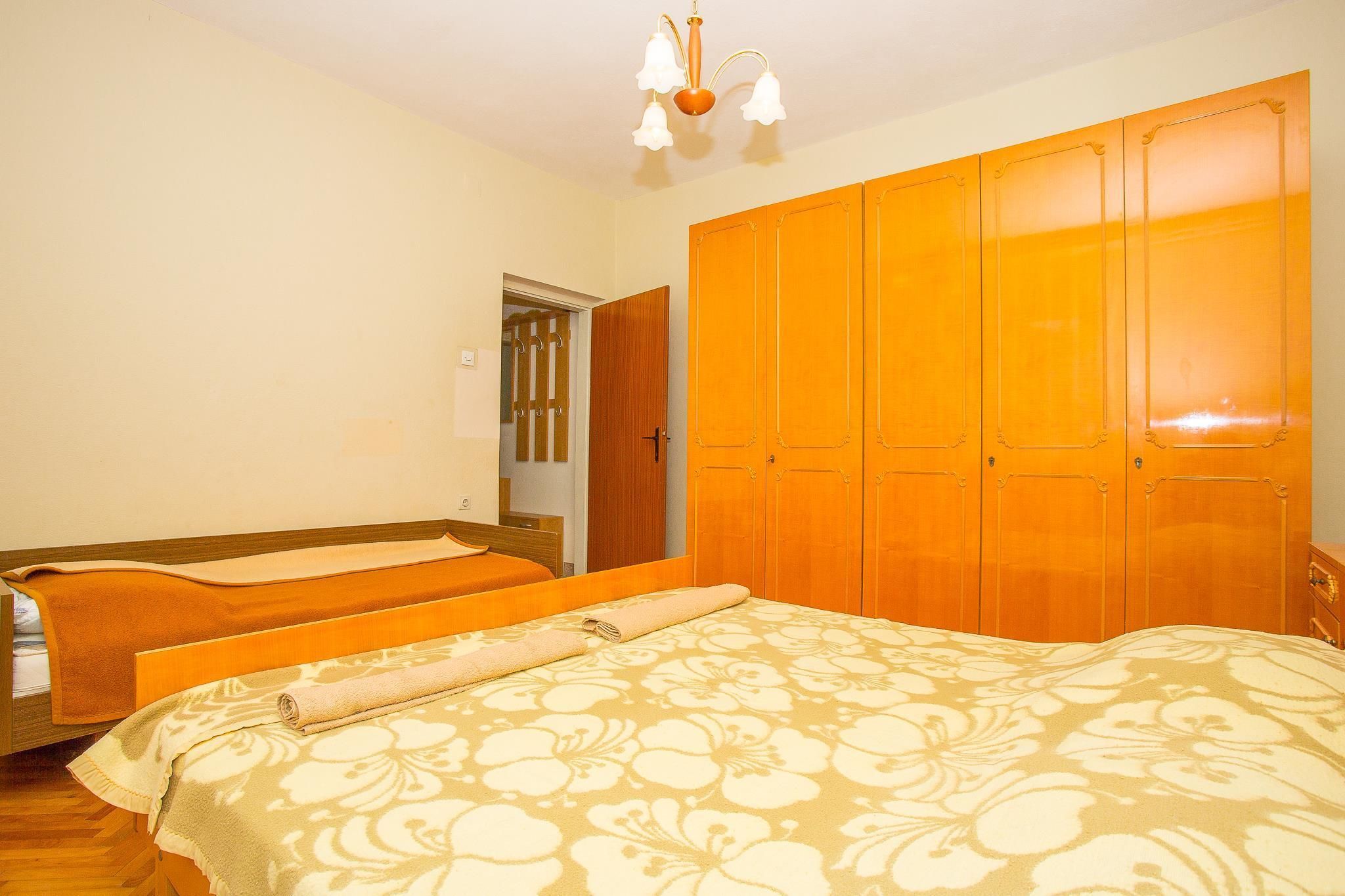 Une chambre à coucher comprenant un lit, une armoire et une porte donnant sur une autre pièce.