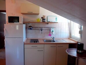 Departamento, varias camas | Cocina privada | Parrilla de estufa y utensilios de cocina