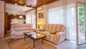 Una sala de estar acogedora con un sofá, una mesita de centro y un comedor con una mesa y sillas.