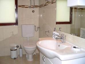 Appartement, plusieurs lits | Salle de bain | Douche, sèche-cheveux, serviettes fournies, shampoing