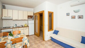 Appartement, 2 lits doubles | Salle de séjour | Téléviseur