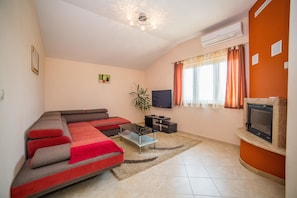 Apartamento, varias camas | Sala de estar | Una televisión