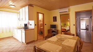 A compact living space with a kitchen, dining area, and a bedroom. - Apartments Pribil (Rab)