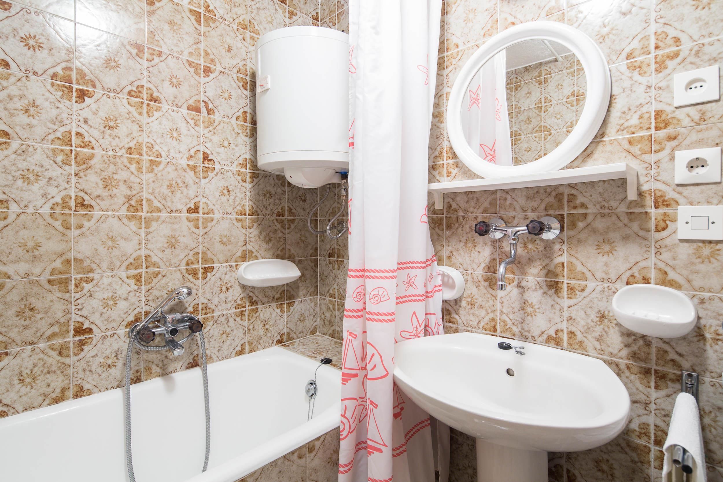 A bathroom with a bathtub, a sink, a toilet, and a shower curtain.