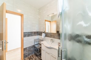 A modern bathroom with a shower, a sink, and a mirror. - Villa St.vid 2 (Vir)