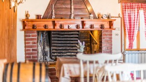A rustic interior with a brick fireplace, wooden shelves, and barrels. - Holiday House Valter (Rasa)