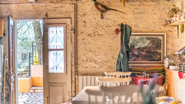 A rustic room with a large window, a door leading outside, and a painting on the wall. - Holiday House Valter (Rasa)