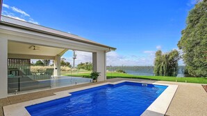 Piscina con vista a un lago y árboles.