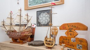 A wooden display with model ships, a framed picture, and a welcome sign. - Apartments Antonija (Rab)
