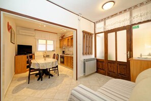 A compact living space with a dining area, kitchenette, and a bed.