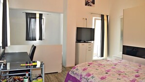 A hotel room with a bed, a desk with a chair, a television, and a wardrobe. - Apartments Ante Seline (Starigrad)