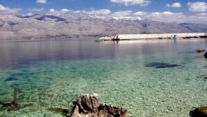 A clear lake with a rocky shoreline and mountains in the background. - Apartments Ante Seline (Starigrad)