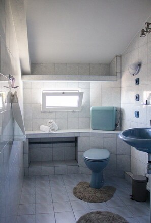 A bathroom with a toilet, sink, and a towel rack. - Apartments Ivo 1728 (Kastela)