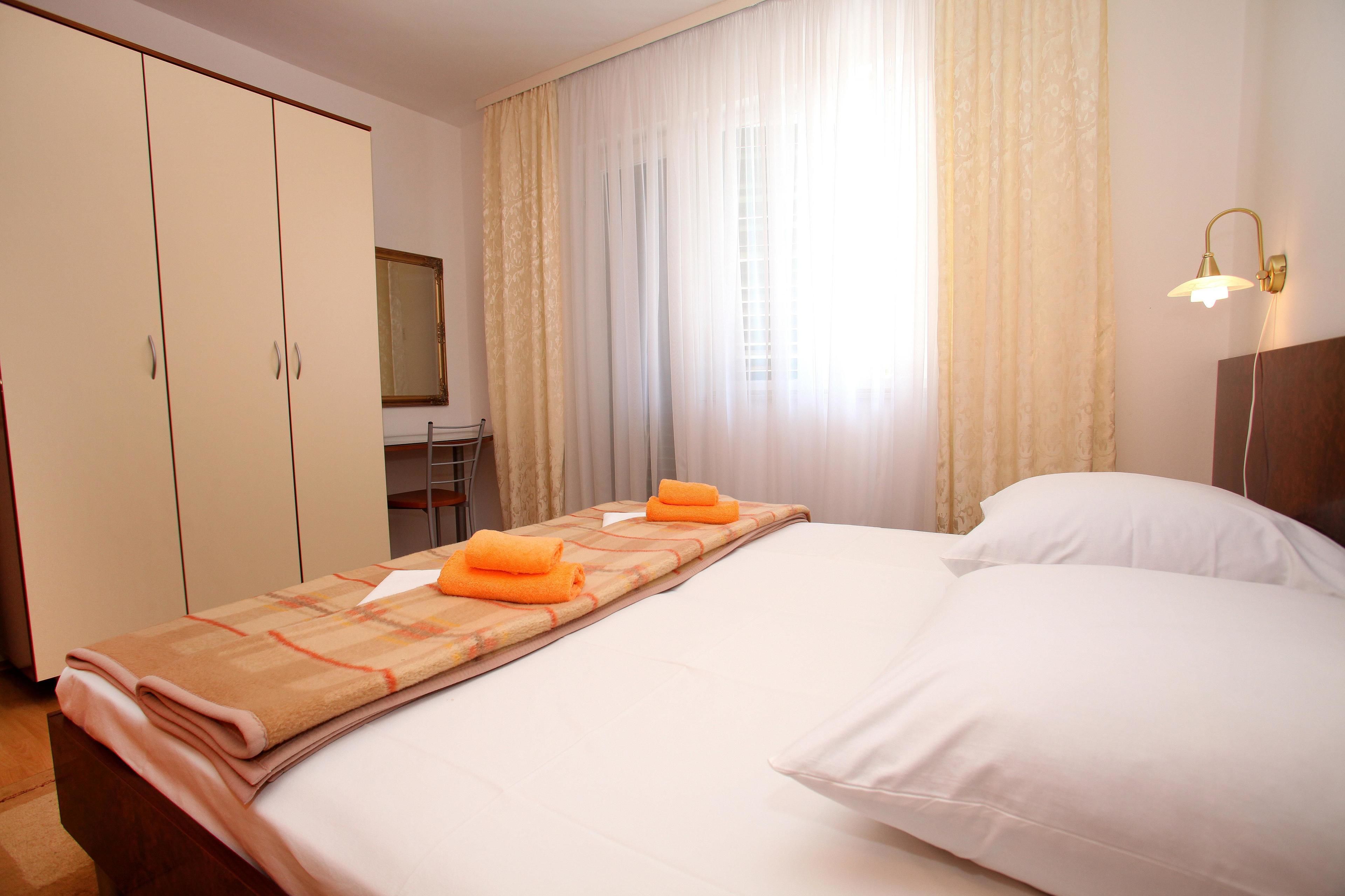 A hotel room with a bed, a desk, and a wardrobe.