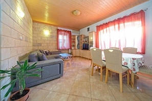 Apartamento, varias camas | Sala de estar | Una televisión
