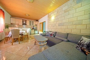 Apartamento, varias camas | Sala de estar | Una televisión