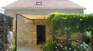 Simple, functional building surrounded by a lush garden with a clothesline for outdoor laundry.